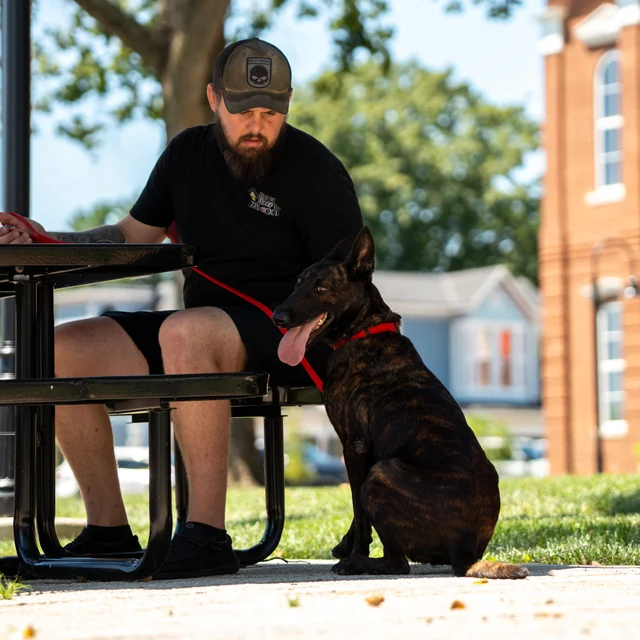 Black Woof Inn trainer with a dog on the La Grange courthouse lawn